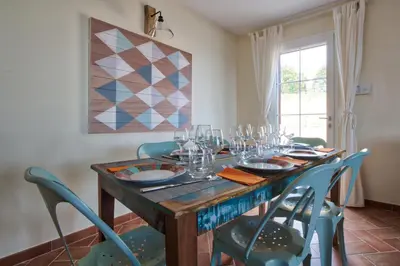 a dining room table with chairs and wine glasses at Le Domaine Saint François La Tour 3 in Ajaccio