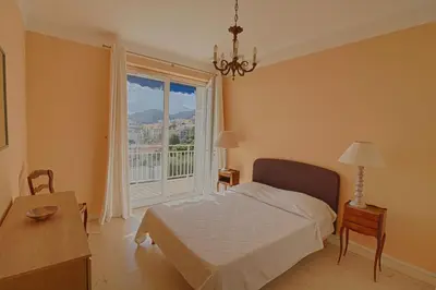 a bedroom with a bed and a large window at Appartement centre ville Les Pins Ajaccio in Ajaccio