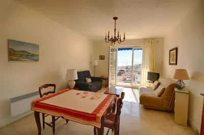 a living room with a table and chairs and a dining room at Appartement centre ville Les Pins Ajaccio in Ajaccio