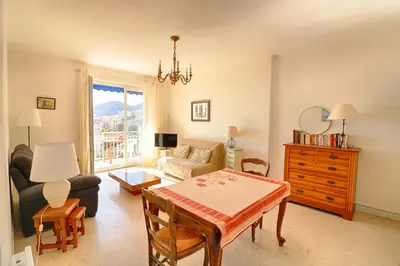 a living room with a table and a couch at Appartement centre ville Les Pins Ajaccio in Ajaccio