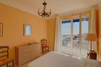 a bedroom with a bed and a dresser and a window at Appartement centre ville Les Pins Ajaccio in Ajaccio