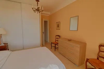 a bedroom with a bed and a dresser and a chair at Appartement centre ville Les Pins Ajaccio in Ajaccio