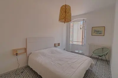 a white bedroom with a bed and a window at Appartement centre ville Citadelle Ajaccio in Ajaccio