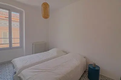 a white bedroom with a bed and a window at Appartement centre ville Citadelle Ajaccio in Ajaccio