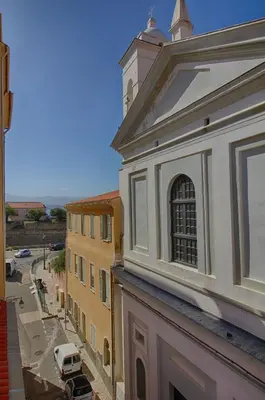 a building with a tower and a street with a car at Appartement centre ville Citadelle Ajaccio in Ajaccio