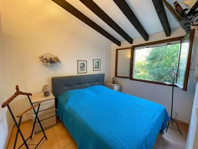 a bedroom with a blue bed and a window at Maison Asco à Santa Giulia in Porto-Vecchio