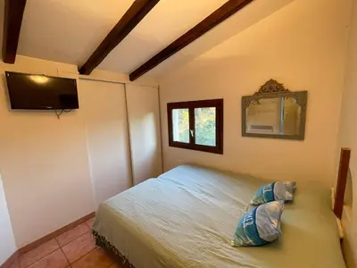 a bedroom with a bed and a television in it at Maison Asco à Santa Giulia in Porto-Vecchio