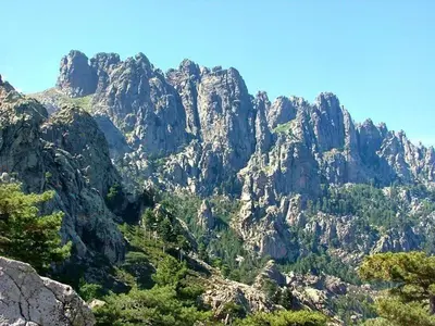 a rocky mountain with trees in front of it at Villa Occhiatana, Santa Giulia in Porto-Vecchio