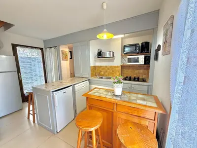a small kitchen with a counter and a refrigerator at Mini villa Erbalunga, Santa Giulia in Porto-Vecchio