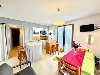 a kitchen with a table with a vase of flowers on it at Mini villa Erbalunga, Santa Giulia in Porto-Vecchio