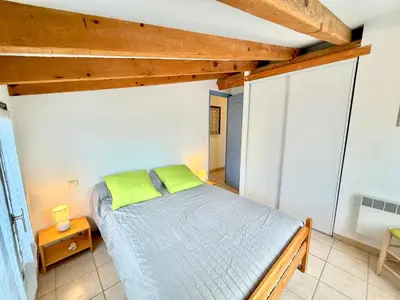 a bedroom with a bed in a room with wooden ceilings at Mini villa Erbalunga, Santa Giulia in Porto-Vecchio