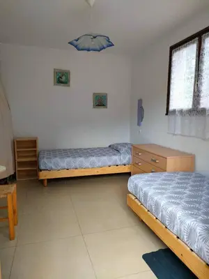 a bedroom with two beds and a blue umbrella at Mini villa Erbalunga, Santa Giulia in Porto-Vecchio