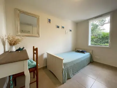 a bedroom with a bed and a mirror and a desk at Villa San Antonu, Santa Giulia in Porto-Vecchio