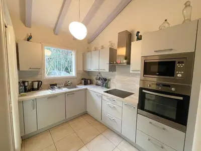 a kitchen with white cabinets and a microwave at Villa San Antonu, Santa Giulia in Porto-Vecchio