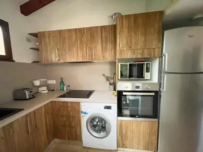 a kitchen with a refrigerator and a washing machine at Villa Tizzano, Santa Giulia in Porto-Vecchio