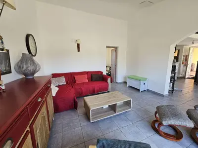 a living room with a red couch and a table at Villa Arca, 5min du centre de Porto-Vecchio in Porto-Vecchio