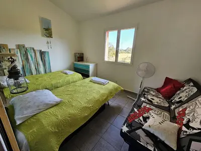a bedroom with two beds and a window at Villa Arca, 5min du centre de Porto-Vecchio in Porto-Vecchio