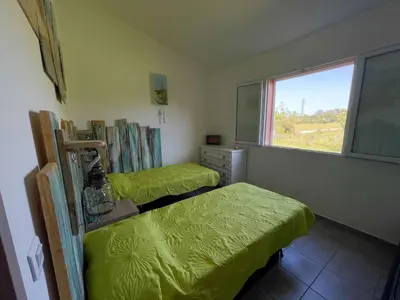a bedroom with two twin beds and a window at Villa Arca, 5min du centre de Porto-Vecchio in Porto-Vecchio