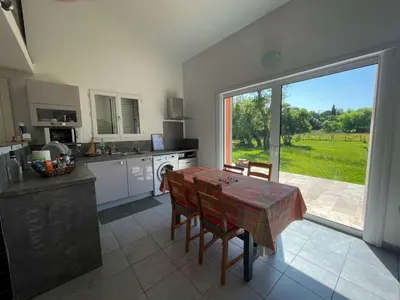 a kitchen with a table and a large window at Villa Arca, 5min du centre de Porto-Vecchio in Porto-Vecchio