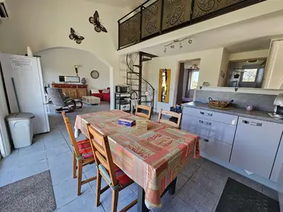a kitchen with a table and some chairs and a kitchen with a kitchen at Villa Arca, 5min du centre de Porto-Vecchio in Porto-Vecchio