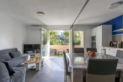 a kitchen and living room with a table and chairs at Le Petra - Appt climatisé proche de la plage in Ajaccio