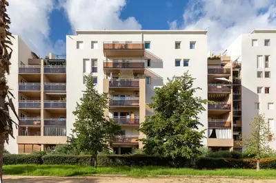 an apartment building with balconies and trees at Le Petra - Appt climatisé proche de la plage in Ajaccio