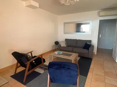 a living room with a couch and a table at Mini villa Hameaux des Sanguinaires AJACCIO in Ajaccio