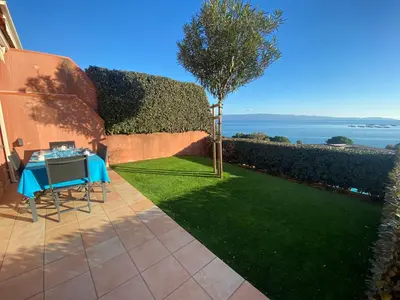 a small garden with a table and a tree at Mini villa Hameaux des Sanguinaires AJACCIO in Ajaccio