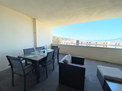 a dining room with a table with wine glasses at Appartement Le Frassu PORTICCIO in Porticcio