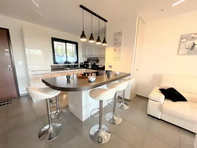a kitchen and living room with a table and chairs at Appartement Le Frasso PORTICCIO in Porticcio