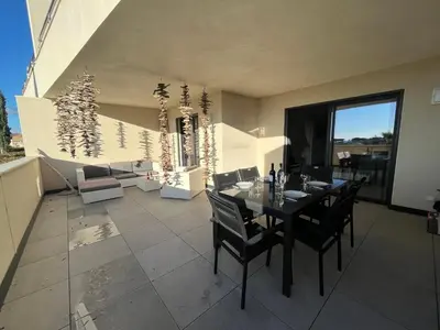 a dining room with a table and chairs on a balcony at Appartement Le Frasso PORTICCIO in Porticcio