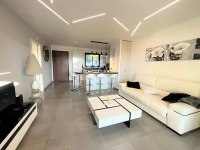 a living room with a white couch and a table at Appartement Le Frasso PORTICCIO in Porticcio