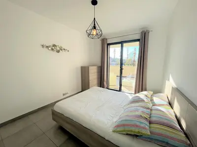 a bedroom with a bed with a window at Appartement Le Frasso PORTICCIO in Porticcio