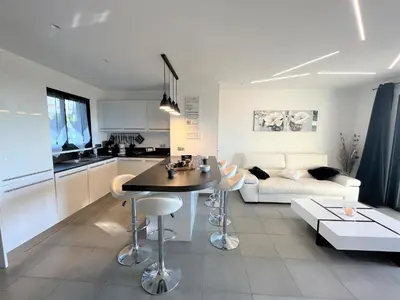 a kitchen and living room with a table and a couch at Appartement Le Frasso PORTICCIO in Porticcio
