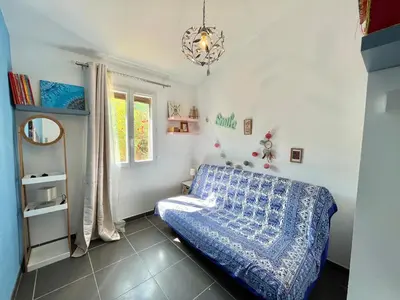 a bedroom with a blue bed and a window at Villa L'Ondella PORTICCIO in Porticcio
