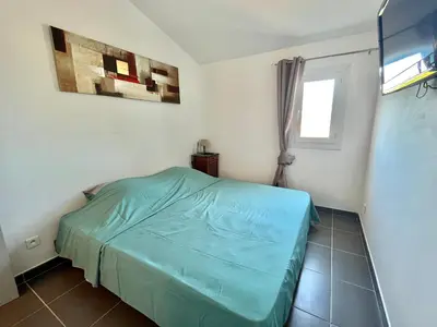 a bedroom with a green bed in a room at Villa L'Ondella PORTICCIO in Porticcio