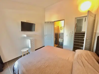 a bedroom with a bed and a flat screen tv at Villa L'Ondella PORTICCIO in Porticcio