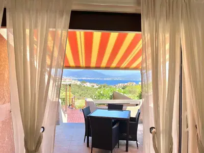 a dining room with a table and a view of the ocean at Villa L'Ondella PORTICCIO in Porticcio