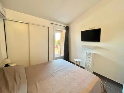 a bedroom with a bed and a tv on the wall at Villa L'Ondella PORTICCIO in Porticcio