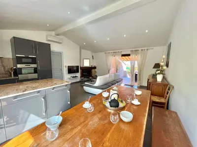 a kitchen and living room with a wooden table at Villa L'Ondella PORTICCIO in Porticcio