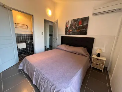 a bedroom with a large bed in a room at Villa L'Ondella PORTICCIO in Porticcio