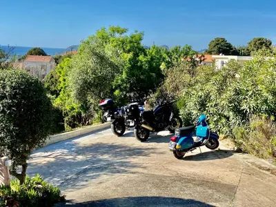 two motorcycles parked on the side of a road at Villa Montalbo vue mer avec grande terrasse & plage à proximité - idéale famille et groupe de 2 à 10 personnes in Cargèse