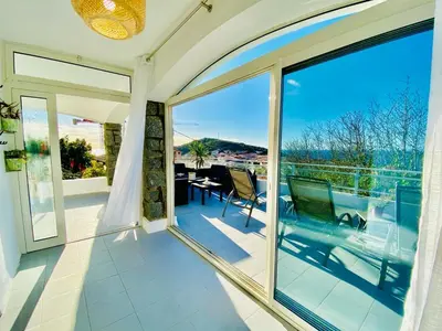 a balcony with a view of a table and chairs at Villa Montalbo vue mer avec grande terrasse & plage à proximité - idéale famille et groupe de 2 à 10 personnes in Cargèse