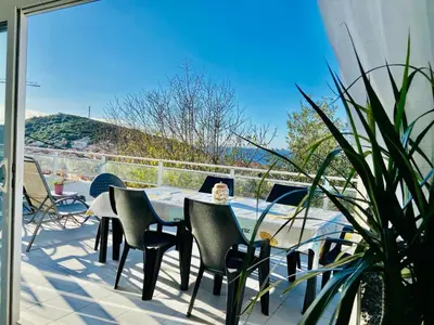 a patio with a table and chairs on a balcony at Villa Montalbo vue mer avec grande terrasse & plage à proximité - idéale famille et groupe de 2 à 10 personnes in Cargèse