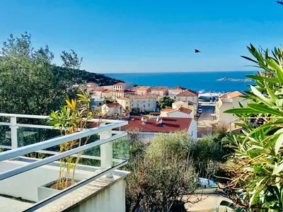 a view of a town with the ocean in the background at Villa Montalbo vue mer avec grande terrasse & plage à proximité - idéale famille et groupe de 2 à 10 personnes in Cargèse