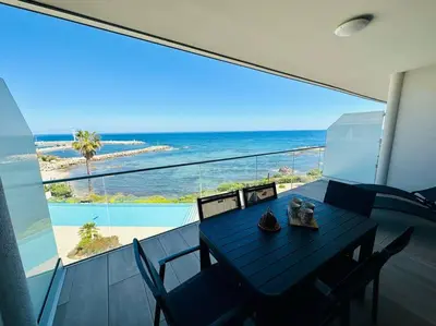 a dining table on a balcony with a view of the ocean at 