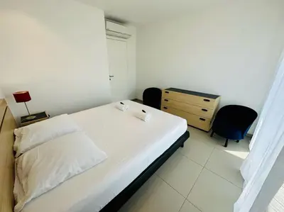a white bedroom with a bed and a dresser at 