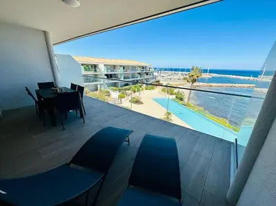 a balcony with a dining table and a view of the ocean at 