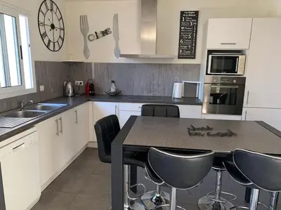 a kitchen with a table and some chairs in it at Villa Fautea Romance in Fautea