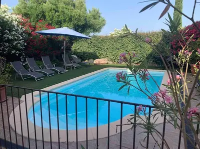a swimming pool with chairs and an umbrella at Villa Fautea Romance in Fautea